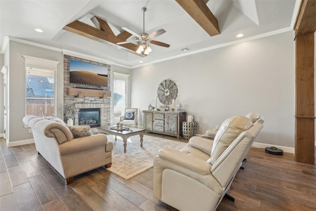 living room featuring ornamental molding, a stone fireplace, wood finished floors, and baseboards