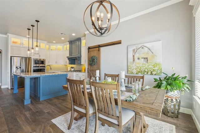 dining area featuring baseboards, a barn door, an inviting chandelier, and crown molding