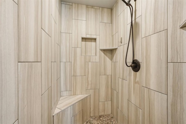 interior details featuring a tile shower