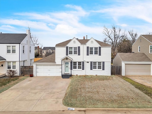 traditional-style home featuring entry steps, concrete driveway, a chimney, roof with shingles, and fence