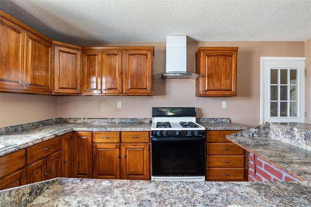 kitchen with wall chimney range hood, brown cabinetry, and range with gas cooktop