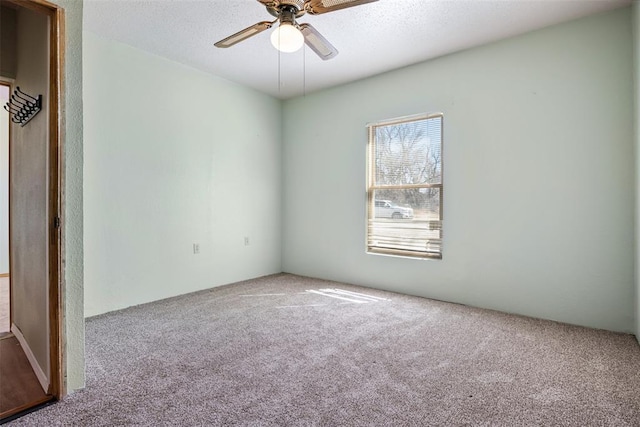 carpeted spare room featuring a ceiling fan and a textured ceiling