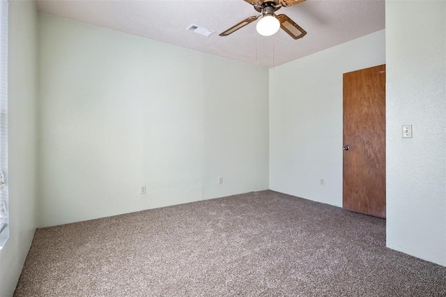 unfurnished room with carpet floors, a textured ceiling, visible vents, and a ceiling fan