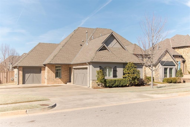 view of front of home featuring a garage, concrete driveway, roof with shingles, and brick siding