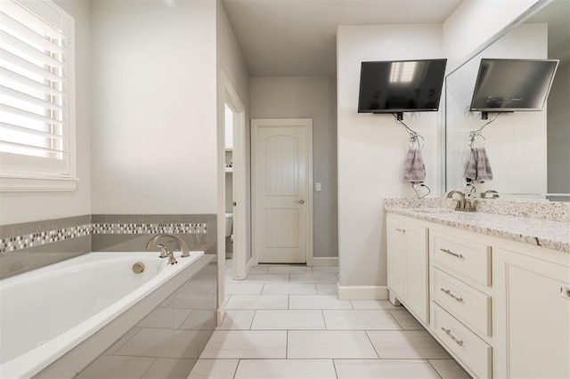 full bath with tile patterned flooring, baseboards, a bath, and vanity