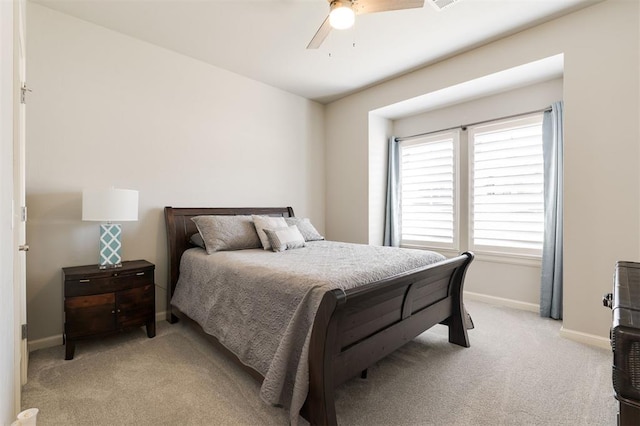 bedroom with light carpet, ceiling fan, visible vents, and baseboards