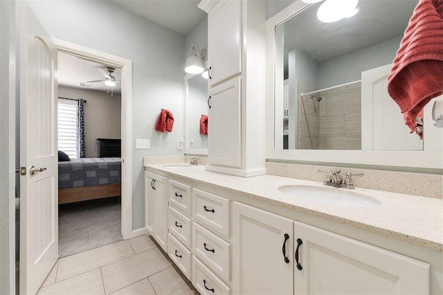 ensuite bathroom with ensuite bathroom, double vanity, tiled shower, and a sink