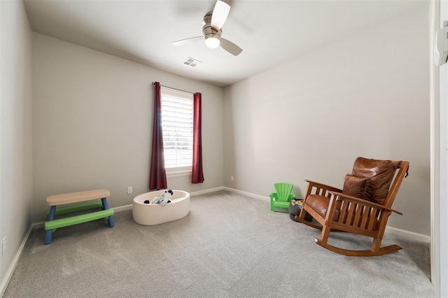 sitting room featuring baseboards, carpet floors, visible vents, and a ceiling fan