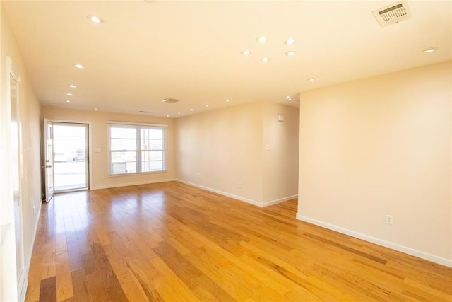 spare room with baseboards, light wood-type flooring, visible vents, and recessed lighting