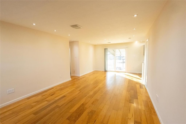 empty room with light wood finished floors, visible vents, baseboards, and recessed lighting