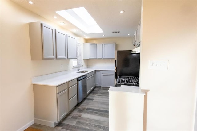 kitchen with visible vents, stainless steel dishwasher, freestanding refrigerator, gas stove, and a sink