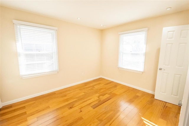 spare room featuring light wood finished floors and baseboards