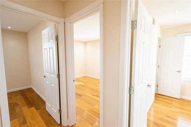 corridor featuring light wood finished floors, recessed lighting, and baseboards