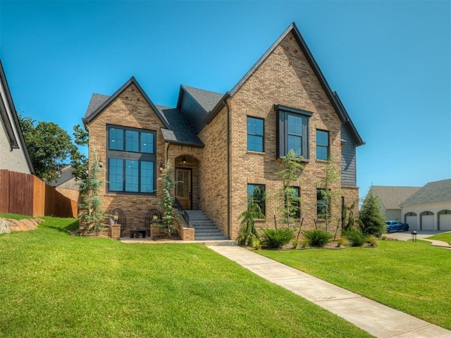 view of front of property with fence, a front lawn, and brick siding