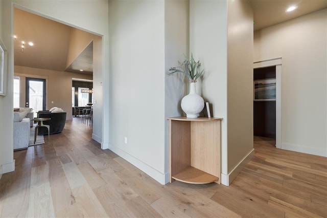 hallway featuring light wood-style floors, recessed lighting, and baseboards