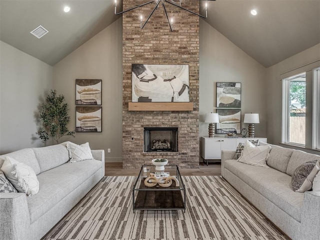 living area with a fireplace, visible vents, wood finished floors, high vaulted ceiling, and baseboards