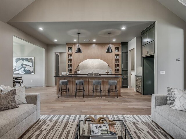 bar featuring light wood-style floors, pendant lighting, backsplash, and recessed lighting