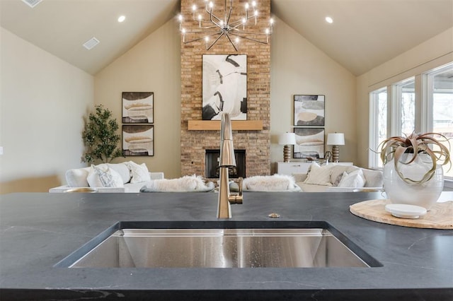 interior details with recessed lighting, a sink, visible vents, a brick fireplace, and dark countertops