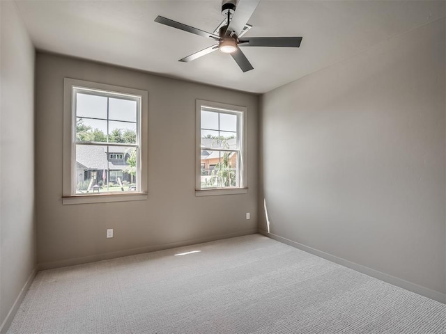 spare room with ceiling fan, carpet floors, and baseboards