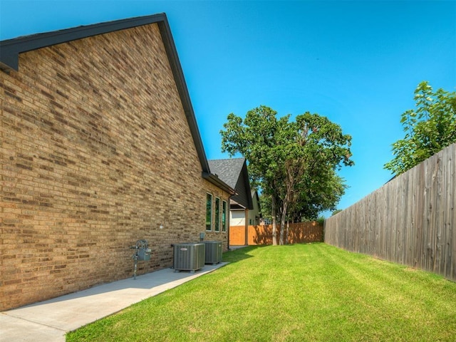 view of yard with central AC unit and a fenced backyard