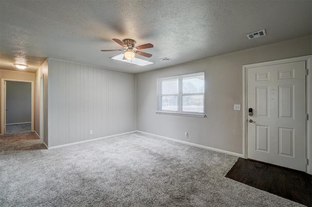 interior space with baseboards, a textured ceiling, visible vents, and a ceiling fan