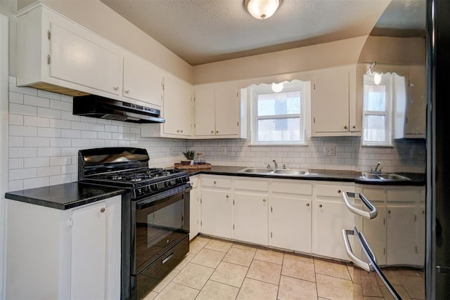 kitchen with black gas range, under cabinet range hood, a sink, white cabinetry, and backsplash