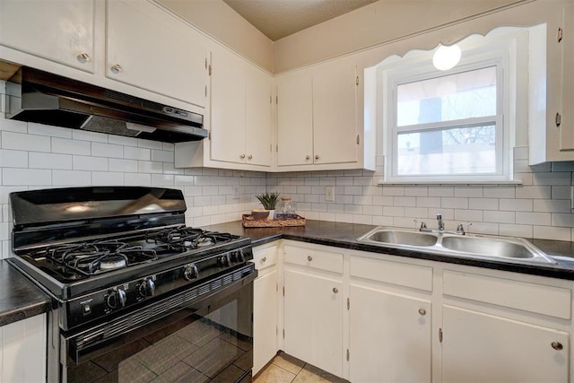 kitchen with black gas range, decorative backsplash, dark countertops, under cabinet range hood, and a sink