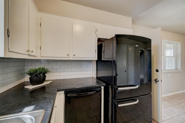 kitchen with decorative backsplash, dark countertops, black appliances, white cabinetry, and a sink