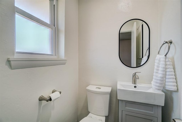 half bathroom with vanity and toilet