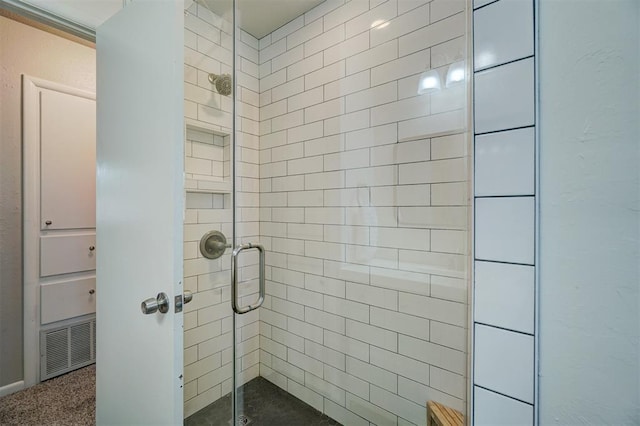 full bath with a shower stall and visible vents