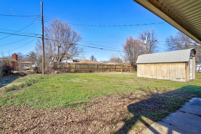 view of yard featuring a fenced backyard, a storage unit, and an outbuilding