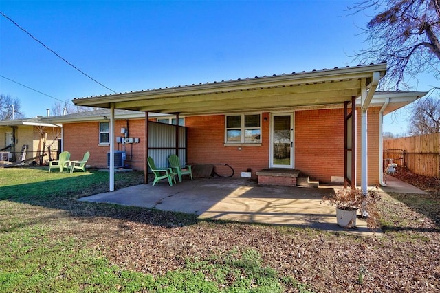 back of property featuring brick siding, central air condition unit, a lawn, entry steps, and fence