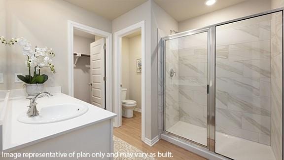 full bath featuring toilet, a stall shower, vanity, wood finished floors, and baseboards