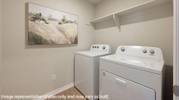 laundry area featuring laundry area, baseboards, wood finished floors, and washing machine and clothes dryer