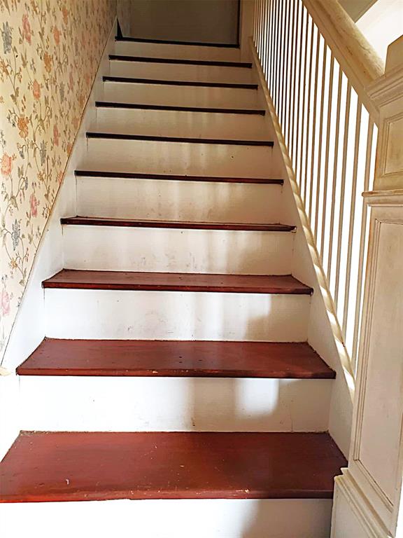 stairway featuring wallpapered walls