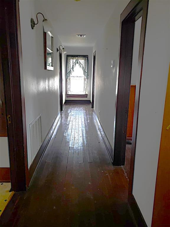 corridor featuring wood-type flooring and visible vents