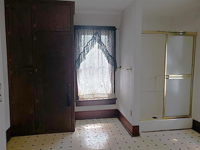 bathroom with a shower stall, baseboards, and tile patterned floors