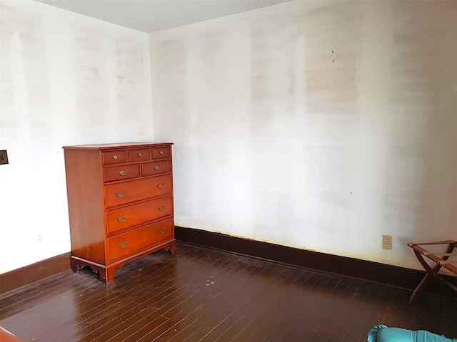 unfurnished room featuring dark wood-style floors and baseboards