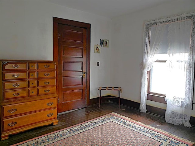 bedroom featuring dark wood-style flooring and baseboards