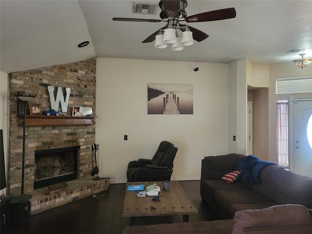 living room with baseboards, visible vents, wood finished floors, vaulted ceiling, and a fireplace