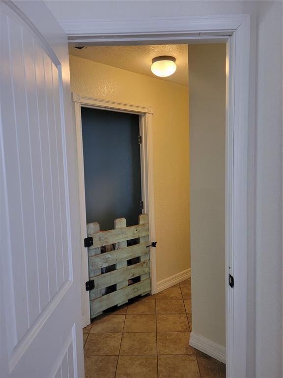 hall with tile patterned flooring and baseboards