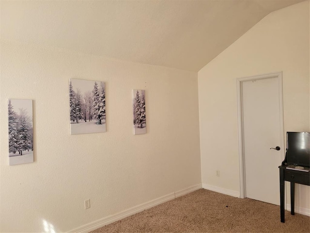 interior space featuring vaulted ceiling, carpet flooring, and baseboards