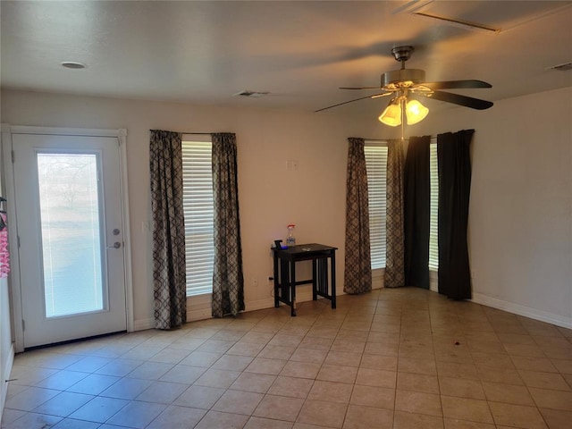 empty room with a healthy amount of sunlight, light tile patterned floors, and visible vents