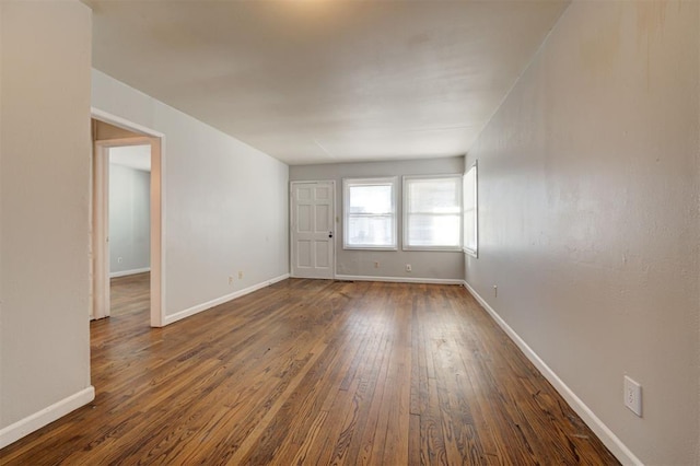 unfurnished room with dark wood-style floors and baseboards