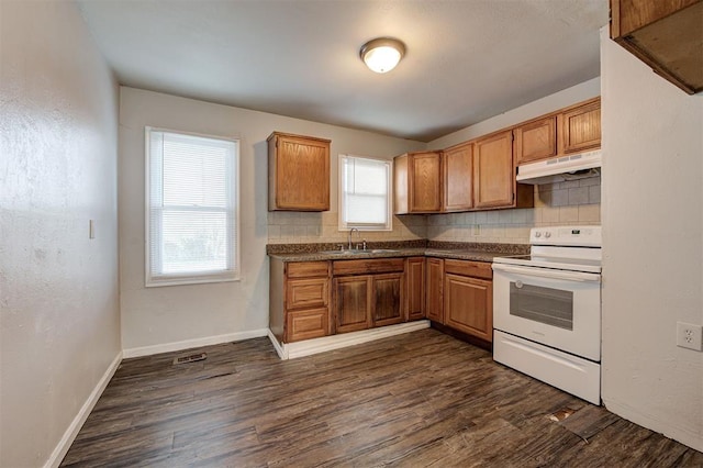 kitchen featuring under cabinet range hood, dark wood-style flooring, a sink, white range with electric stovetop, and dark countertops