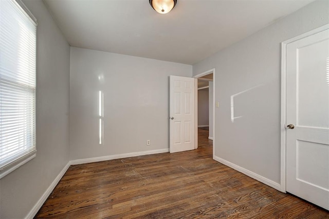 unfurnished bedroom featuring baseboards and wood finished floors