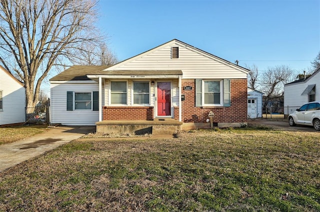 bungalow with a front yard and brick siding