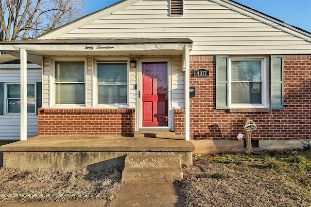 bungalow featuring brick siding