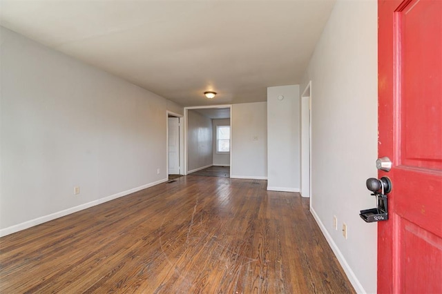 unfurnished room with dark wood finished floors and baseboards