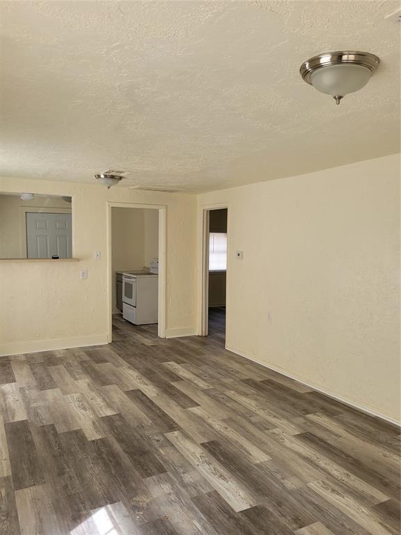 spare room with a textured ceiling and dark wood-style flooring